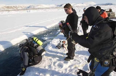 Divers preparing to enter crack or lead in sea ice. Divers preparing to enter crack or lead in sea ice.