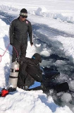 Diver preparing to descend in crack or lead in sea ice. Diver preparing to descend in crack or lead in sea ice.