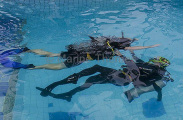 Diver and instructor in resort swimming pool practicing CESA (Controlled Emergency Swimming Ascent) Diver and instructor in resort swimming pool practicing CESA (Controlled Emergency Swimming Ascent)