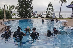 Beginner divers being instructed in resort swimming pool. Confined water lessons. Beginner divers being instructed in resort swimming pool. Confined water lessons.