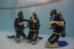 Dive instructor helping students to learn mask removal and replacement while underwater. Dive instructor helping students to learn mask removal and replacement while underwater.