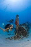 Divers swimming over aeroplane wreck, a WWII Corsair fighter plane. Divers swimming over aeroplane wreck, a WWII Corsair fighter plane.