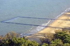 Aerial view of swimming enclosure on tropical ocean beach with netting to provide protection for swimmers against potentially fatal jellyfish stings. Aerial view of swimming enclosure on tropical ocean beach with netting to provide protection for swimmers against potentially fatal jellyfish stings.