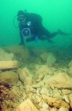 Diver with video camera swimming over rubble slope created by dredging operations. Diver with video camera swimming over rubble slope created by dredging operations.