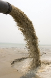 Sand dredge in operation at the mouth of a river entering a large bay. Sand dredge in operation at the mouth of a river entering a large bay.
