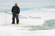 Inuit hunter waiting with harpoon next to seal's breathing hole in sea ice. Inuit hunter waiting with harpoon next to seal's breathing hole in sea ice.