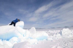 Inuit hunter scanning sea ice for seals from high vantage point created by pressure from wind and tides. Inuit hunter scanning sea ice for seals from high vantage point created by pressure from wind and tides.