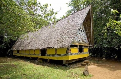 Traditional Bai meeting hall in Palau, Micronesia, with story board artwork on gables containing ocean themes including fish and sharks.