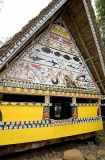 Traditional Bai meeting hall in Palau, Micronesia, with story board artwork on gables containing ocean themes including fish and sharks.