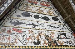 Traditional Bai meeting hall in Palau, Micronesia, with story board artwork on gables containing ocean themes including fish and sharks.