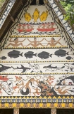 Traditional Bai meeting hall in Palau, Micronesia, with story board artwork on gables containing ocean themes including fish and sharks.
