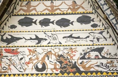 Traditional Bai meeting hall in Palau, Micronesia, with story board artwork on gables containing ocean themes including fish and sharks.
