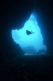 Diver passing entrance to underwater cave system. Diver passing entrance to underwater cave system.