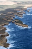 Aerial of rugged shoreline washed by rough seas at sunset. Aerial of rugged shoreline washed by rough seas at sunset.