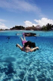 Young girl swimming underwater in tropical island beach shallows. Young girl swimming underwater in tropical island beach shallows.