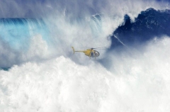 A helicopter filming a tow-in surfer at Peahi (Jaws)