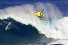 A helicopter filming a tow-in surfer at Peahi (Jaws)