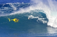 A helicopter filming a tow-in surfer at Peahi (Jaws)