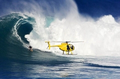 A helicopter filming a tow-in surfer at Peahi (Jaws)