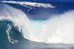 A helicopter filming a tow-in surfer at Peahi (Jaws)