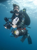 Diver with rebreather scuba equipment hovering under dive boat while undergoing decompression stop. Diver with rebreather scuba equipment hovering under dive boat while undergoing decompression stop.