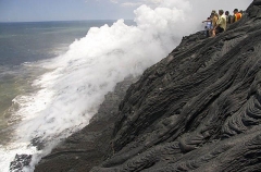 Tourists observing lava flowing into the ocean. Tourists observing lava flowing into the ocean.