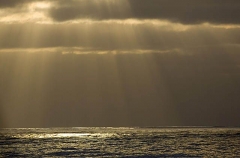 Sunbeams through storm cloads over open ocean. Sunbeams through storm cloads over open ocean.